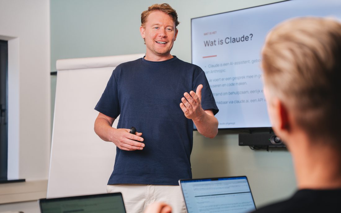 Maarten Oostland geeft de Claude Workshop, op het scherm achter hem staat Wat is Claude