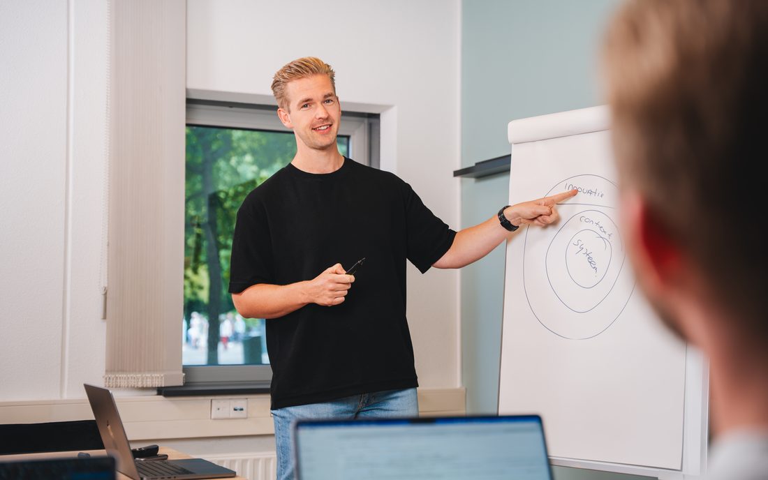 Een workshop van Empathree, met uitleg aan een flipover voor een kleine groep